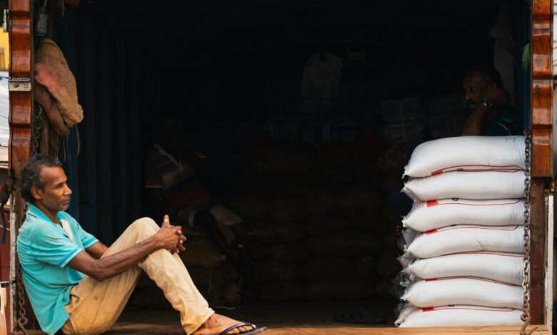 Man sitting on truck tailgate with stacked white bags